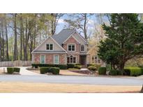 Charming brick home with manicured landscaping and mature trees offers great curb appeal at 6935 York Pl, Cumming, GA 30040