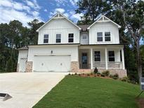 Charming two-story home with white siding, brick accents, a well-manicured lawn and a three car garage at 30 Riverrock Trl, Dallas, GA 30157