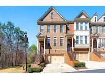 Charming brick townhome featuring a well-manicured lawn, attached garage, and classic architectural details at 4852 Merriman Se Walk # 23, Atlanta, GA 30339