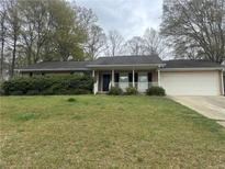 Charming single-story home featuring a well-maintained lawn and an attached two-car garage at 1430 Country Lane Ne Dr, Conyers, GA 30012