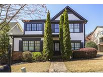 Charming two-story home with black trim, fresh landscaping, and inviting stone walkway at 1784 Hollingsworth Nw Blvd, Atlanta, GA 30318