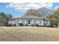 Stunning one story home featuring a symmetrical design, manicured landscaping, and a welcoming entrance at 8671 Lake Forrest Dr, Douglasville, GA 30134