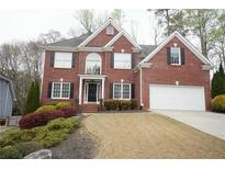 Charming two-story brick home with well-manicured landscaping, and an attached two car garage at 1191 Crofton Landing, Suwanee, GA 30024