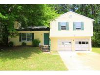 Charming two-story home with a two-car garage, complemented by green shutters at 2238 Scarbrough Dr, Stone Mountain, GA 30088