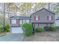 Charming split-level home with gray siding, red shutters, and a well-maintained front yard at 3094 Calumet Nw Cir, Kennesaw, GA 30152