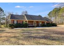 Ranch-style brick home with a dark roof, manicured shrubs, and a welcoming front porch at 105 Ruff Harris Dr, Dallas, GA 30157