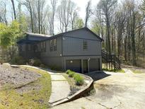 Two-story home with gray siding, a two-car garage, and a landscaped front yard surrounded by mature trees at 2919 Manitoba Ln, Marietta, GA 30062
