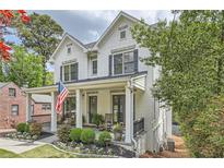 Charming two-story white brick home with a welcoming front porch, landscaped yard and an American flag at 555 E Wesley Ne Rd, Atlanta, GA 30305