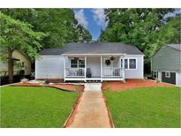 Charming single story home with a cozy front porch, green lawn and a walkway to the front door at 1094 Regent Sw St, Atlanta, GA 30310