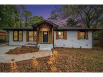 Charming home with a manicured lawn, brick facade, and stylish wood accents at 1934 Pinedale Pl, Decatur, GA 30032