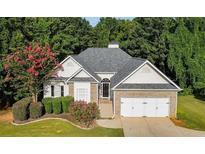 Charming single-Gathering home featuring a brick facade and a manicured lawn, complemented by mature trees at 5915 Windsorcreek Dr, Douglasville, GA 30135