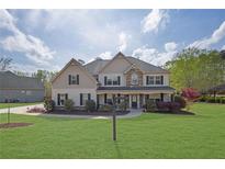 Charming two-story home with a beautifully landscaped front yard and inviting covered porch at 115 Bellemeade Ct, Fayetteville, GA 30215