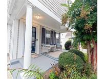 Inviting front porch with neutral chairs, a rug, and a view of the landscaped front yard at 1488 Cottage Way #32, Marietta, GA 30066