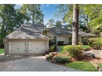 Charming home featuring a two-car garage and a beautifully landscaped front yard at 2100 Stone Hollow Ct, Marietta, GA 30062