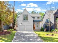 Charming two-story white home featuring a paved driveway, two-car garage, and a well-manicured lawn at 1299 Sunland Ne Dr, Brookhaven, GA 30319