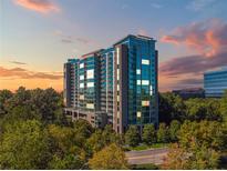 Modern high-rise condominium with reflective glass facade and verdant tree canopy at 3300 Windy Ridge Se Pkwy # 1309, Atlanta, GA 30339