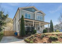 Charming two-story home with a welcoming front porch and well-manicured landscaping on a sunny day at 1611 Flat Shoals Rd, Atlanta, GA 30316
