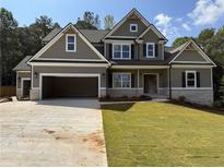 Charming two-story home featuring an attached two car garage and a well-maintained front lawn at 1081 Holly Dr, Loganville, GA 30052