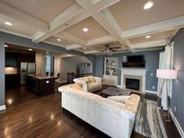 Inviting living room featuring a coffered ceiling, fireplace, and seamless flow into the kitchen area at 2114 Westhill Dr, Smyrna, GA 30082