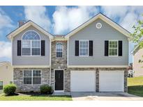 Charming two-story home with stone accents, black shutters, and a two-car garage at 2590 Carolina Rdg, Riverdale, GA 30296