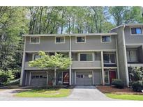 A multi-level townhome with neutral siding, a small front yard, and a private garage for each unit at 2929 Torreya Se Way, Marietta, GA 30067