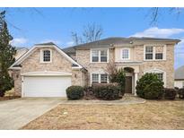 Charming two-story brick home with attached garage, manicured landscaping, and inviting entrance at 5658 Greensage Dr, Atlanta, GA 30349