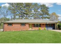 Charming brick home with a well-maintained lawn, complemented by a cheerful yellow front door at 2738 Westchester Dr, Atlanta, GA 30344