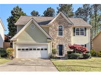 Charming two-story home featuring a combination of stone and siding, plus a two-car garage and a manicured lawn at 3707 Mcguire Nw St, Kennesaw, GA 30144