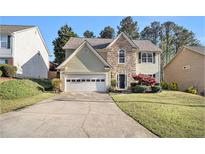 Charming two-story home features a stone accent facade, light siding, and attached garage at 3707 Mcguire Nw St, Kennesaw, GA 30144