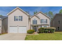 Charming two-story home featuring a well-manicured lawn, a two-car garage and traditional architecture at 4097 Rosebud Park Dr, Snellville, GA 30039
