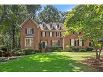 Charming brick home featuring a well-manicured lawn and mature trees at 788 Old Paper Mill Dr, Marietta, GA 30067