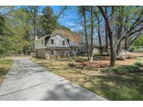 Charming two-story home featuring a brick foundation, vinyl siding, and a long driveway at 403 Red Oak Ln, Lawrenceville, GA 30046