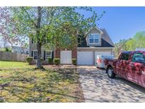 Charming two-story home featuring a two-car garage, brick accents, and a well-manicured lawn at 705 Brentwood Pkwy, Stockbridge, GA 30281