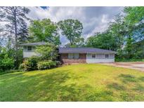 Charming single-Gathering home features a brick facade, well-maintained lawn, and lush landscaping at 1956 Joseph Ct, Decatur, GA 30032