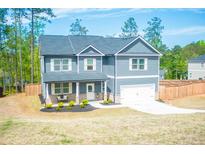 Two-story home with gray siding, white trim, an attached garage and well-manicured lawn in a suburban setting at 284 Bryson Lake Cir, Douglasville, GA 30134