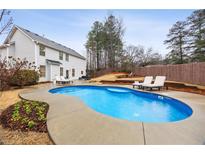 Backyard pool with lounge chairs and manicured landscaping for outdoor relaxation and entertaining at 3600 Kasner Nw Ct, Kennesaw, GA 30144