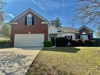 Charming two-story home featuring a brick facade and a well-maintained front yard at 4192 Medlock River Ct, Snellville, GA 30039