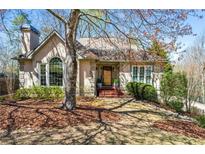 Charming home features a tan exterior, arched window, mature landscaping, and a welcoming front entrance at 3897 Beacon St, Marietta, GA 30062
