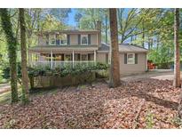 Charming two-story home with a cozy front porch and mature trees at 5269 Blue Grass Ln, Sugar Hill, GA 30518