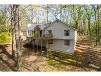 Two-story home with a deck surrounded by mature trees at 3378 Peachtree Chase, Duluth, GA 30096