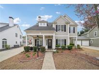 Charming two-story home featuring a welcoming front porch, landscaped yard, and classic architectural details at 3800 Lake Pass Ln, Suwanee, GA 30024