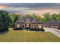 Charming brick home featuring manicured landscaping and attached garage at 5055 Stefan Ridge Way, Buford, GA 30519