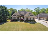Charming single-Gathering home featuring a lush lawn, manicured shrubs, and a welcoming entrance at 5055 Stefan Ridge Way, Buford, GA 30519