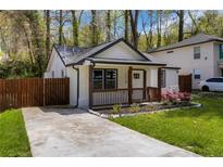Charming renovated cottage home featuring a freshly painted exterior, inviting porch, and well-manicured front yard at 1318 Graymont Sw Dr, Atlanta, GA 30310