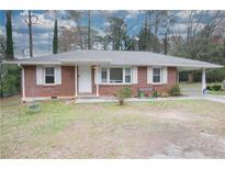 Charming brick home with white shutters, well-lit entryway, and a spacious carport at 1693 Montreal Rd, Tucker, GA 30084