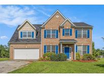 Charming two-story brick home with blue shutters and well-manicured lawn at 1027 Fellowship Rd, Fairburn, GA 30213