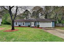 Charming home featuring a manicured front lawn, a two-car garage, and classic landscaping at 4111 Sweet Water Ct, Conyers, GA 30094