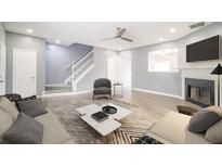 Cozy living room with modern furnishings, fireplace, and open staircase at 74 Venture Path, Hiram, GA 30141