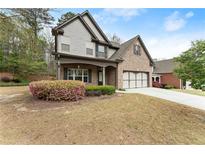 Charming two-story home featuring a brick and gray siding exterior, with a well-manicured lawn at 2172 Misty Brook Ct, Buford, GA 30519