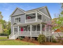Charming two-story home with a inviting porch and eye-catching pink doors at 791 Woodland Se Ave, Atlanta, GA 30316